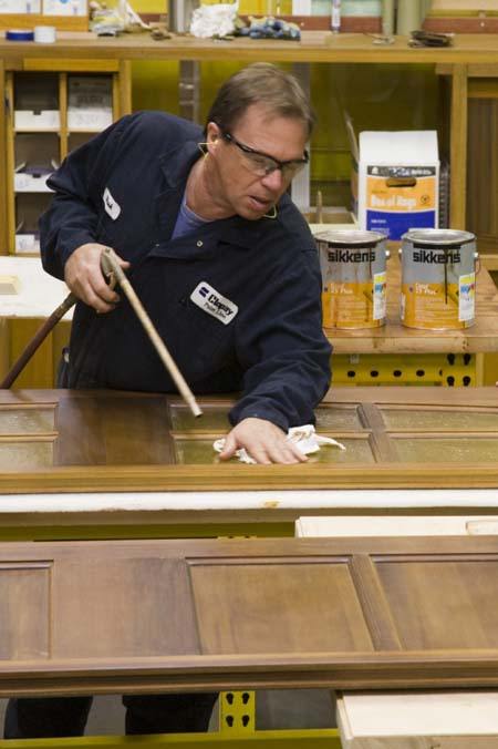 Artisan working on Clopay wood garage doors in their wood manufacturing facility.