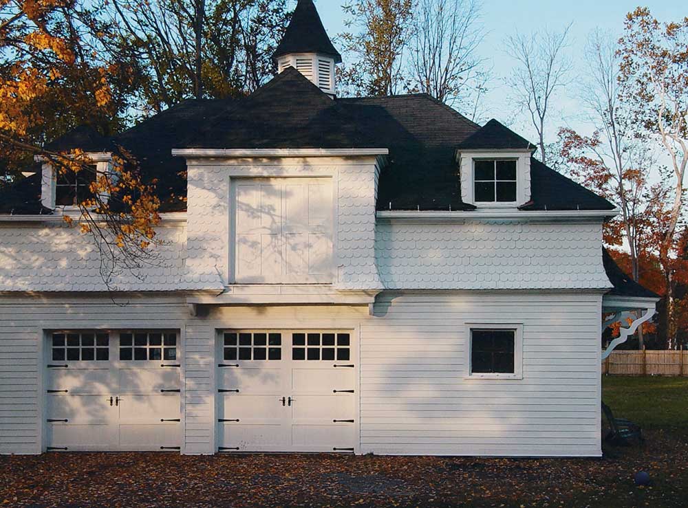 Clopay Reserve Wood Garage door in white with decorative hardware for victorian home